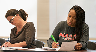 An image of two adult students in class. 