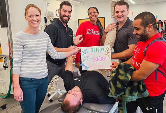 Image of DPT students posing as they perform stretching excercise.