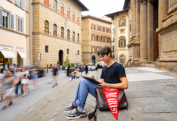 Image of Marist's First-year Florence student working on their lap top outside.