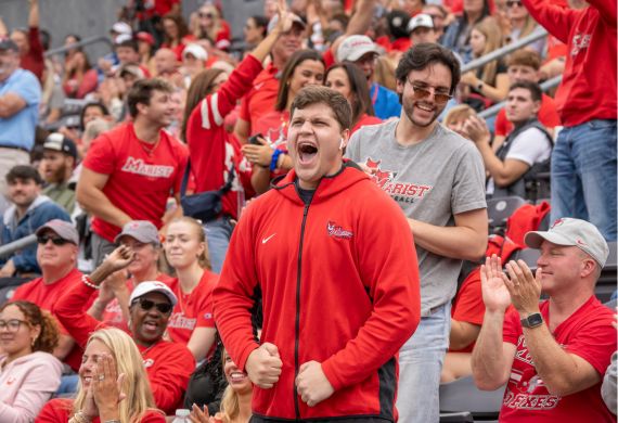 Image of Marist University students cheering at a football game.