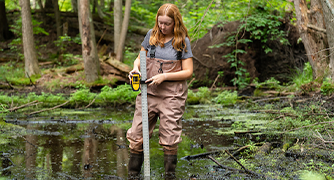 Image of Marist environmental science student taking readings in marsh.