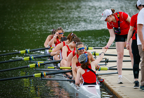 Image of Carina Pascucci ’26 in the stern of the boat receiving encouragement from Assistant Rowing Coach Marguerite McGahay ’25.