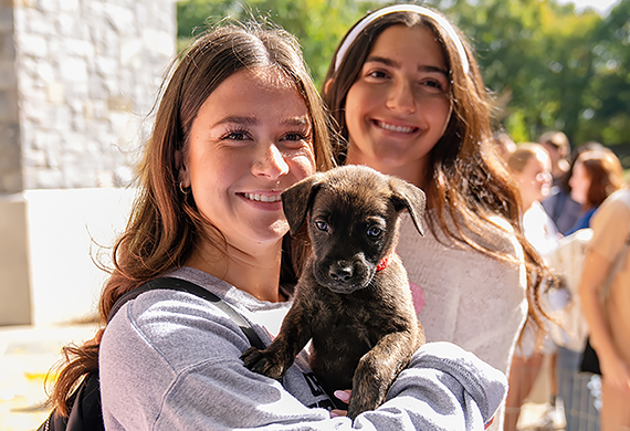 Image of student holding a puppy.