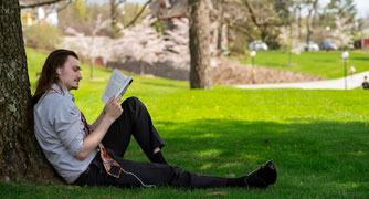 Image of person reading on campus.