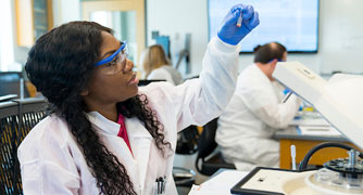 Image of a student in a laboratory looking at a sample.