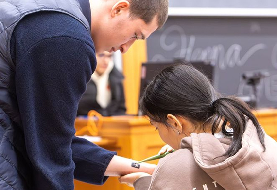 Participants at the Mehendi Workshop tracing intricate henna patterns with the help of design templates. Photo by Emily Portnov ‘29/Marist University.