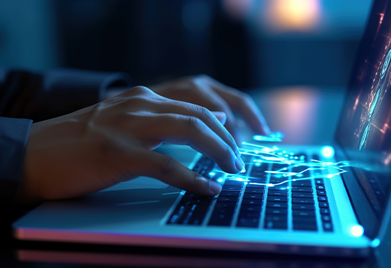 Hands typing on a laptop keyboard with sparks of light coming out of the fingers