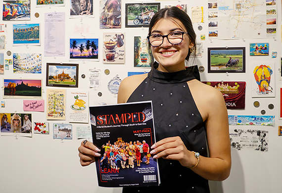 Megan Doshi ’26 poses in front of her displays, celebrating the opening of her exhibit.