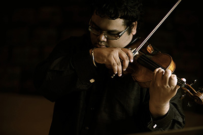 An image of Robert Gupta playing a violin.