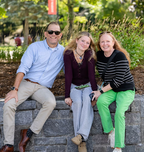 Image of a family sitting under a tree on the Marist University campus.