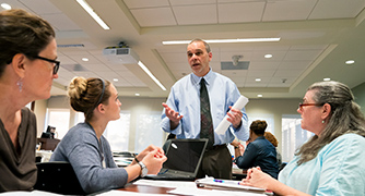 Photo of faculty helping adult students