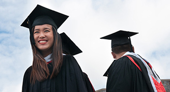 Photo of student with graduation cap and gown