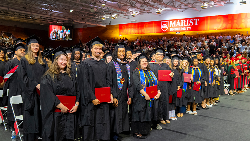 Image of students with their diplomas at the Graduate Commencement ceremony.
