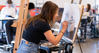 image of a student drawing on a canvas