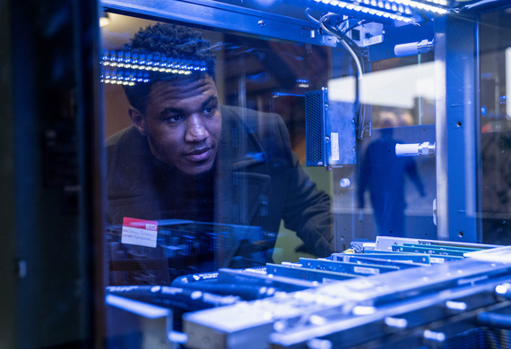 Image of a student examining information technology infrastructure in an on-campus lab.