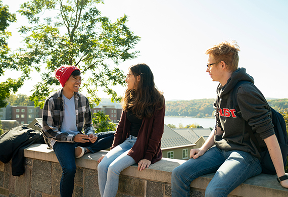 An image of students sitting on a ledge.