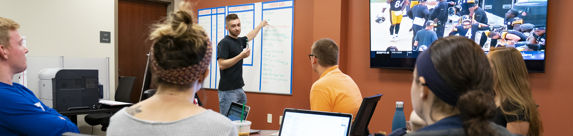 An image of a group of Sport Communication students working on a project together