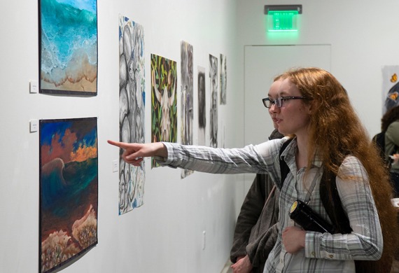 An image of students examining art in a gallery.