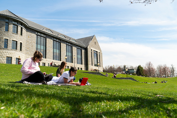 An image of students sitting outside on campus.