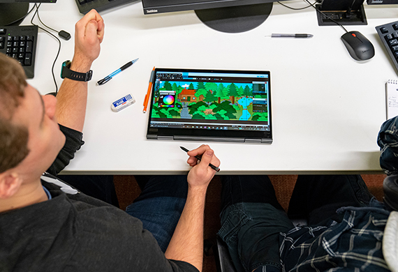 Marist University Games and Emerging Media Studies students designing on a laptop.