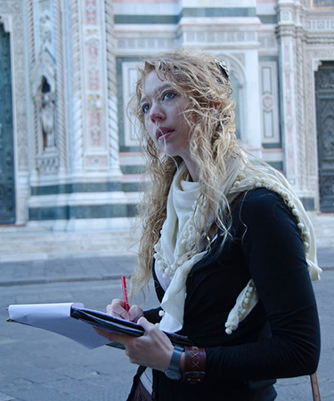 Photo of student walking and writing in Florence