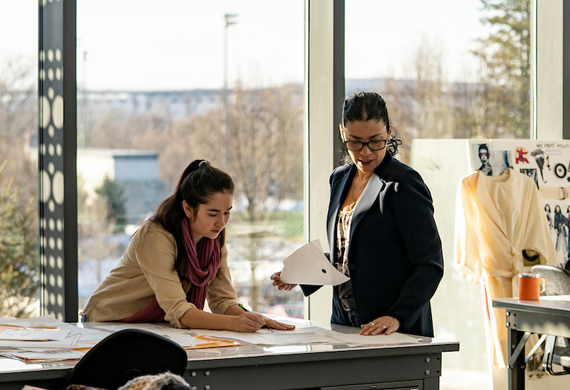 Image of student working with faculty member in senior fashion lab.