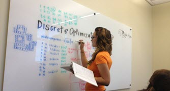 Photo of person writing on white board