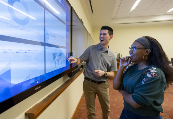 Image of Marist University Computer Science program students looking at a smart board. 