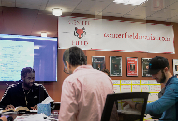 Image of students and faculty working collaboratively in the Center for Sports Communication.