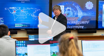 Image of cybersecurity professor teaching class.