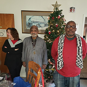 Prof. Elizabeth Purinton-Johnson delivers knitted items to Liberty Station veterans Steven Thompson and Robert Jones