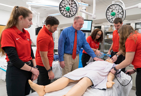 Image of faculty member demonstrating use of medical equipment during class.