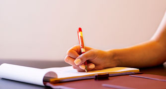 Image of a hand writing on paper.