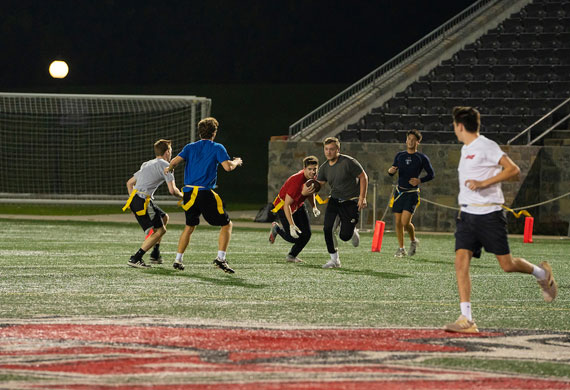 An image of students competing in intramural flag football at Tenney Stadium.