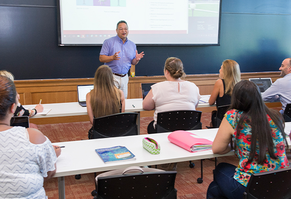 Image of faculty member presenting in a classroom setting.