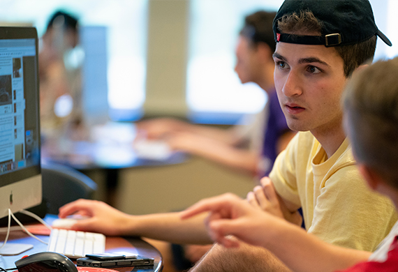 Image of students collaborating on a digital media project.