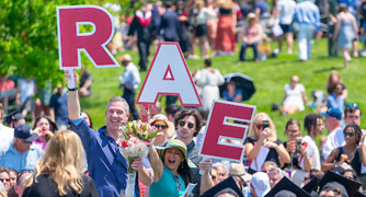 Image of a family supporting their student with signs at commencement.