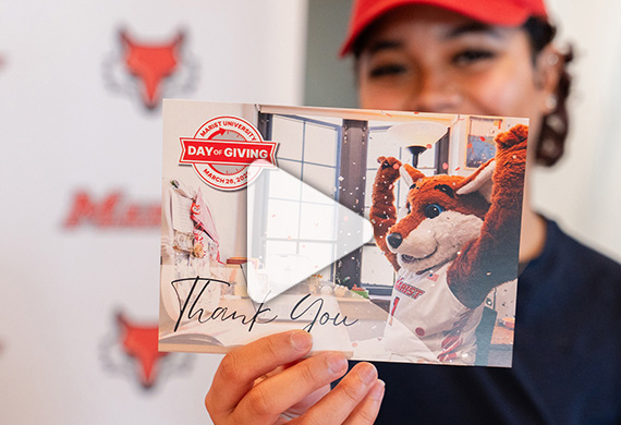 Image of student holding up Day of Giving thank you card.