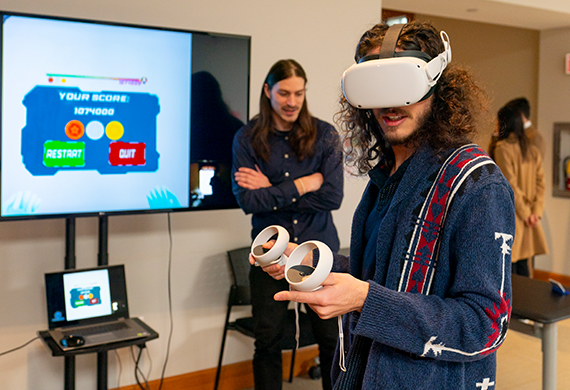 Image of student wearing virtual reality goggles testing out a game.