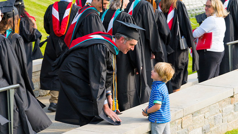 Graduate Jim Brophy MPA greeted by his son Linden during the Commencement procession.