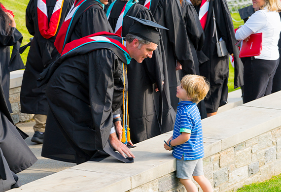 Graduate Jim Brophy MPA greeted by his son Linden during the Commencement procession.