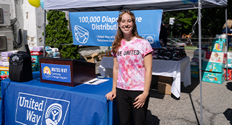 Image of Tarver Intern in front of a United Way booth.