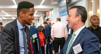 Image of a student interacting with an alumnus.