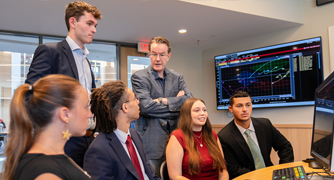 Image of students learning from a faculty member in the investment center.