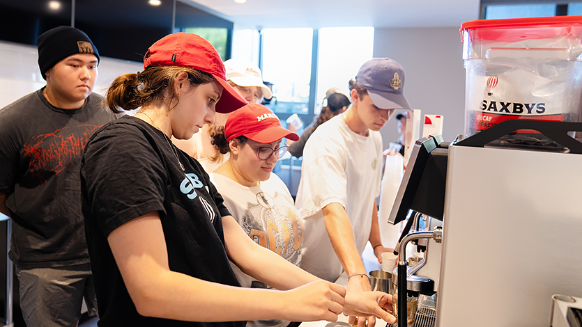 Image of students working behind the counter at Saxbys.