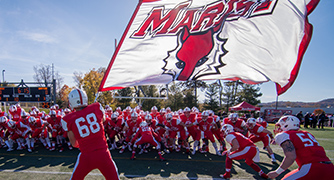Photo of football players waving a Marist flag