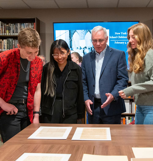 Image of Long Reach Society scholars looking at history documents.