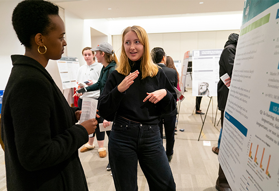 An image featuring multiple posters with individuals engaged in professional discussions.