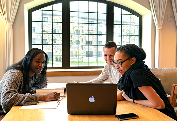 Image of students looking at a laptop