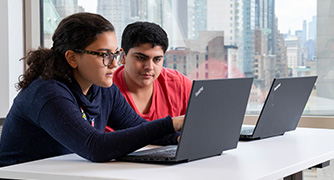 An image of students working on laptops. 